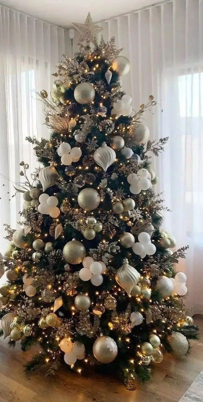 a decorated christmas tree with white and silver ornaments