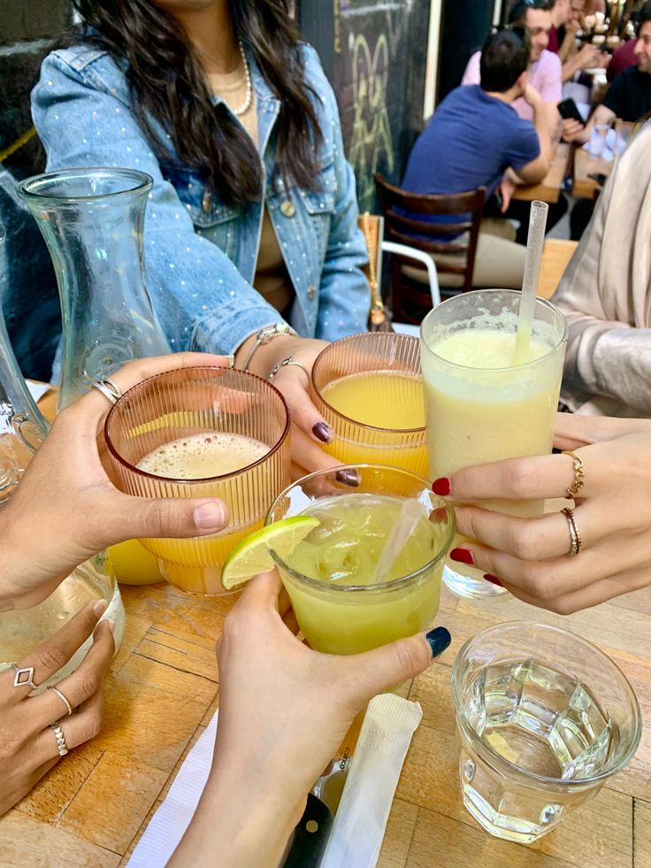 several people are holding glasses with drinks in them