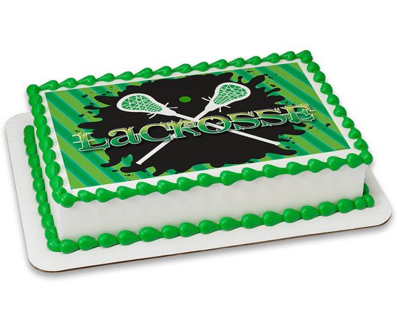 a green and white cake with two tennis racquets on the top it says lacrosse