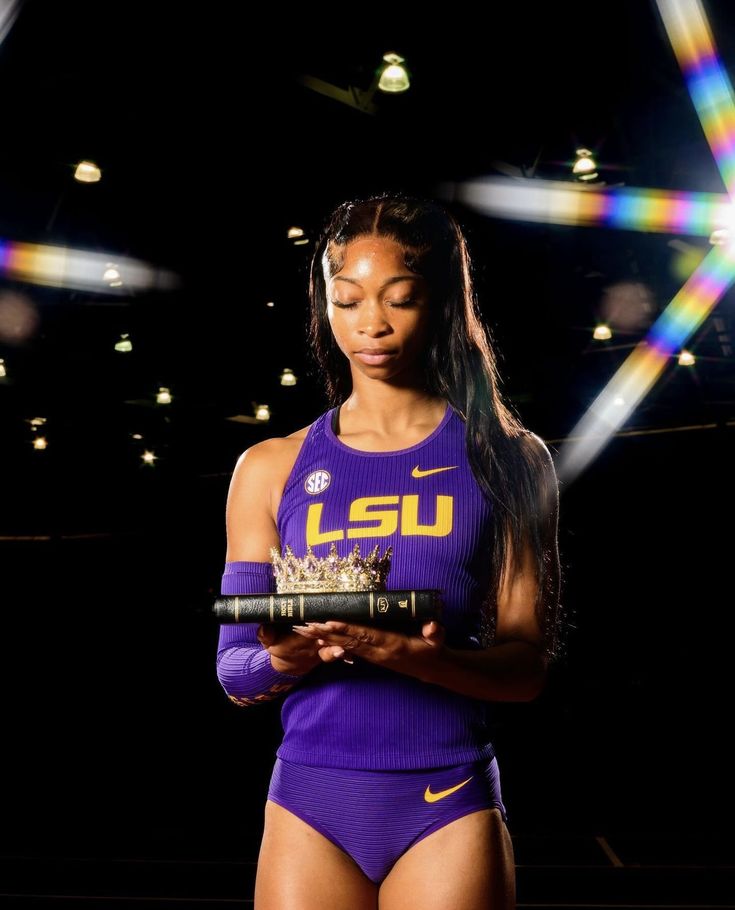 a woman in purple is holding a trophy and looking at her cell phone while standing on a stage