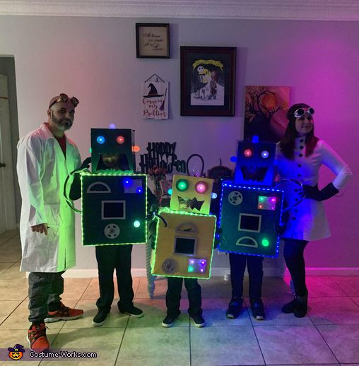 three people dressed up in costumes standing next to each other with glowing lights on their faces