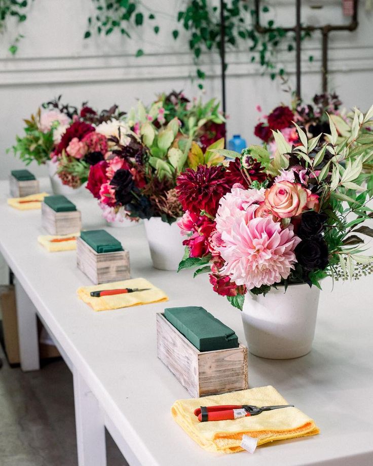 flowers in vases are lined up on the table