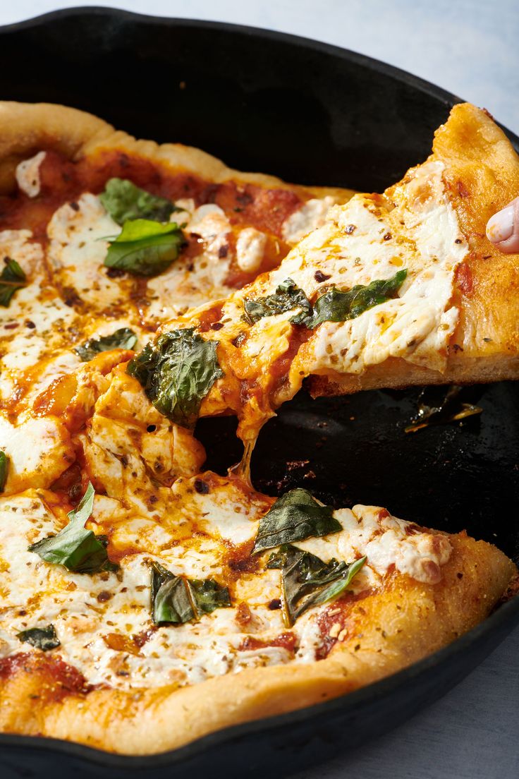 a person taking a slice of pizza from a pan with the words cast iron pizza on it