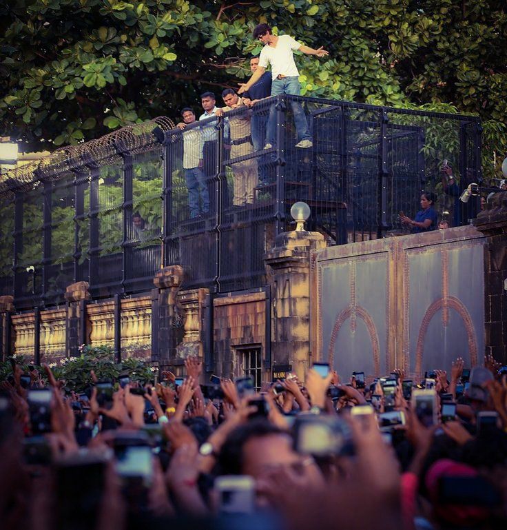 a group of people standing on top of a metal fence