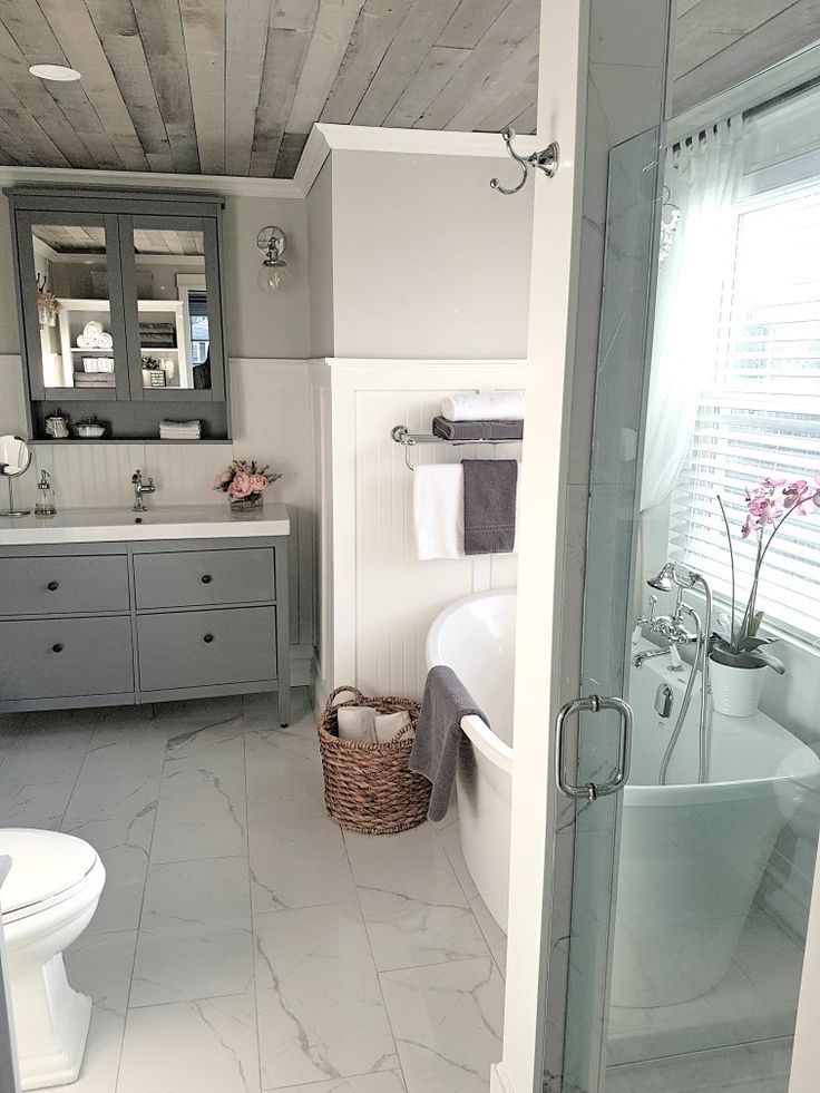 a bathroom with a tub, toilet and sink in it's center piece is shown