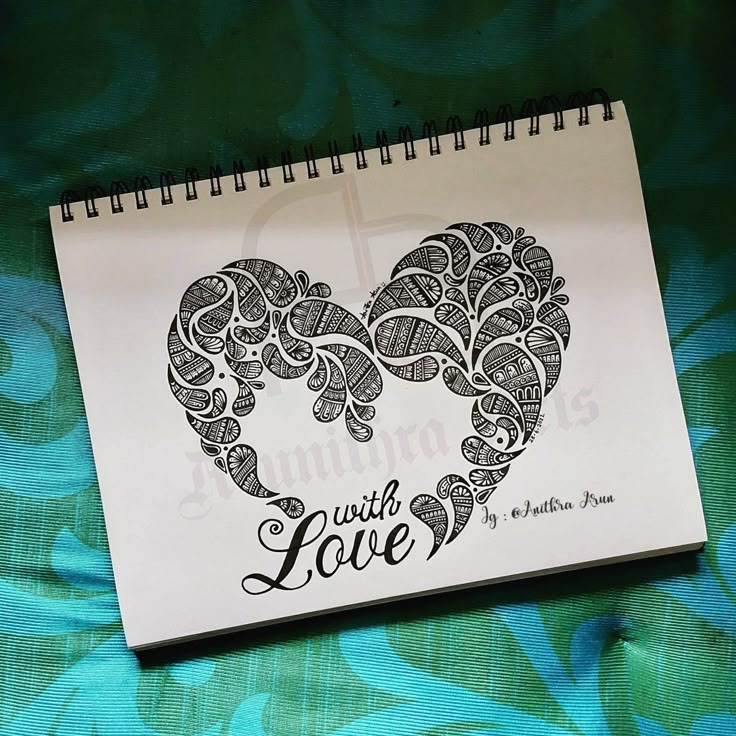 a spiral notebook with the words wild love written in black ink on a green floral background