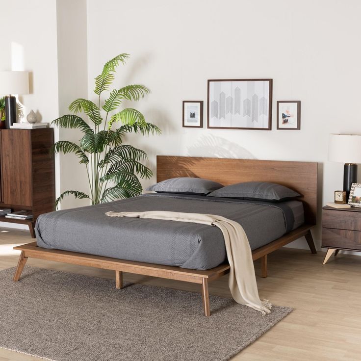 a bed sitting on top of a wooden frame in a bedroom