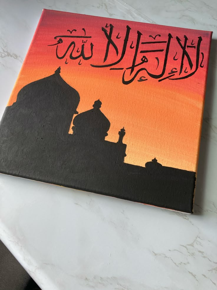 a painting on a table with the words in arabic and an image of a mosque