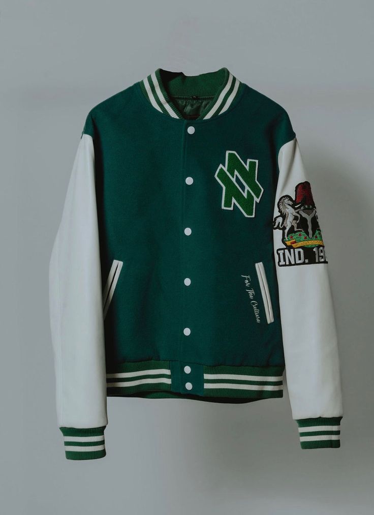 Varsity Jackets have never gone out of style and we’re bring you the Nigerian edition! You can find exquisite patch work of the Naija Nation slogan on the back of this oversized jacket as well as embroidered details on the front pocket. The Nigerian coat of arms graces the leather sleeves of this stylish piece. This product is FINAL SALE. Once this product is purchased you can no longer return or exchange it. SPECS COLOR: Forest Green & White MATERIAL: 50% Cotton/50% Polyester Fleece Knit SIZING Green Embroidered Logo Outerwear For Streetwear, Embroidered Cotton Outerwear For Streetwear, Fall Streetwear Outerwear With Embroidered Patch, Urban Outerwear With Embroidered Patch For College, Urban Outerwear With Embroidered Graphics For College, Embroidered Cotton Varsity Jacket For Streetwear, Cotton Outerwear With Embroidered Graphics For College, Urban Outerwear With Embroidered Patch For Streetwear, Green Patchwork Outerwear For College