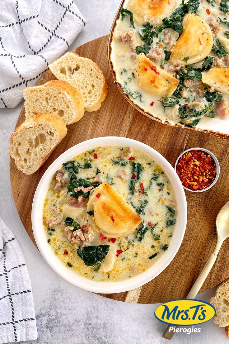 two bowls of soup and bread on a cutting board