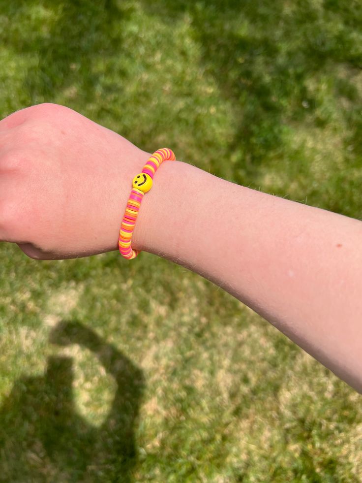 The sunset smiley bracelet is a bracelet with three colors pink, orange, and yellow. The bracelet has a smiley face charm in the middle and has a customizable length. Use code SMILEYBRACELETS10 for 10% off at checkout when you purchase 3 or more bracelets Trendy Everyday Bracelet With Smiley Face, Trendy Everyday Bracelets With Smiley Face, Trendy Everyday Smiley Face Bracelet, Casual Orange Bracelet For Friendship, Playful Adjustable Yellow Bracelets, Cute Smiley Face Bracelets For Friendship, Yellow Adjustable Playful Bracelets, Pink Smiley Face Jewelry For Everyday, Adjustable Yellow Playful Bracelets