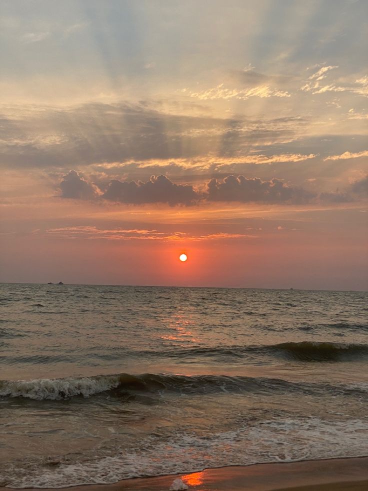 the sun is setting over the ocean with waves