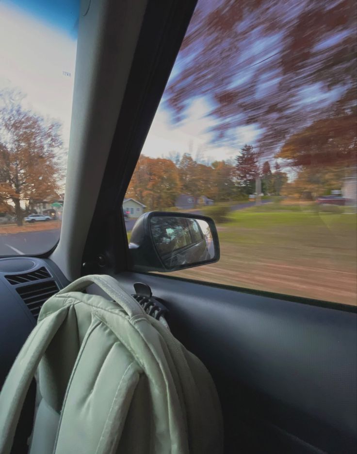 a backpack is sitting in the passenger seat of a car as it drives down the road