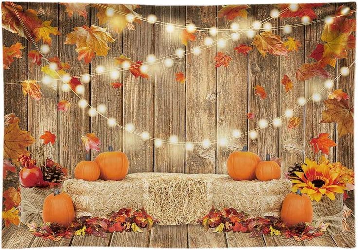 an autumn scene with pumpkins and fall leaves on a table cloth, surrounded by lights