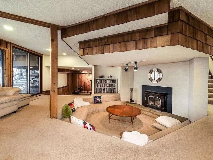 a living room with couches and a fire place in the middle of the room