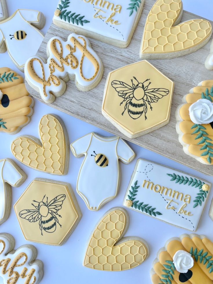 decorated cookies with bees and honeycombs are on a table next to the cookie cutters