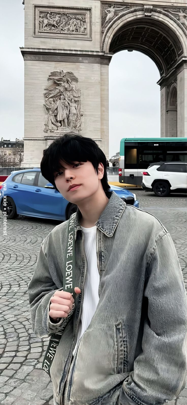 a young man is standing in front of the arc de trioe