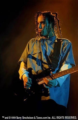 a man with dreadlocks playing a guitar on stage