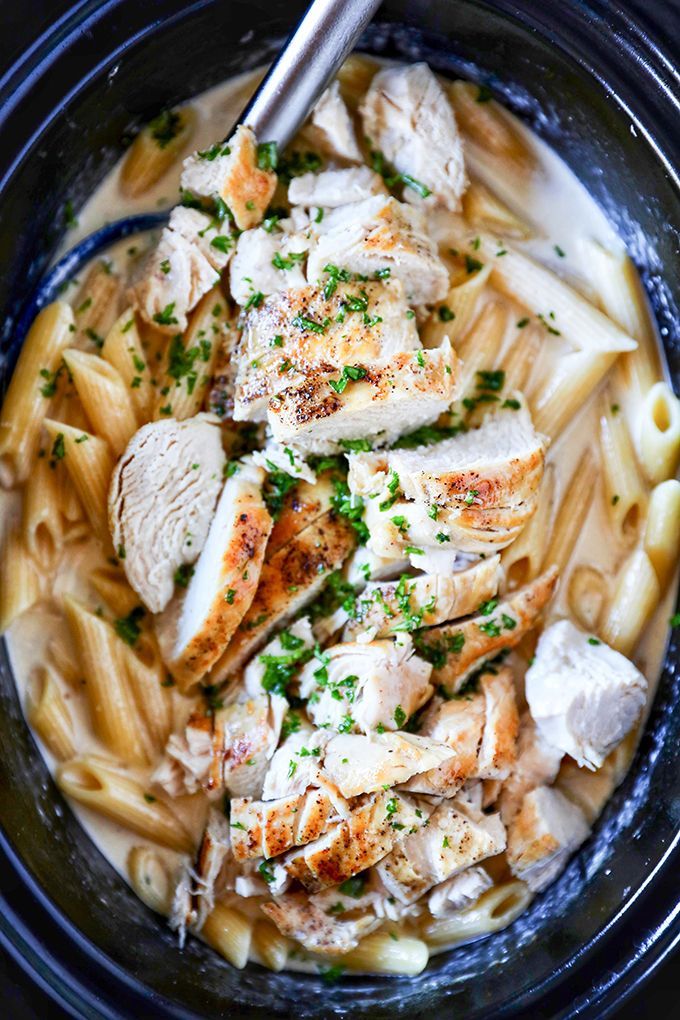 a bowl filled with pasta and chicken covered in parmesan cheese