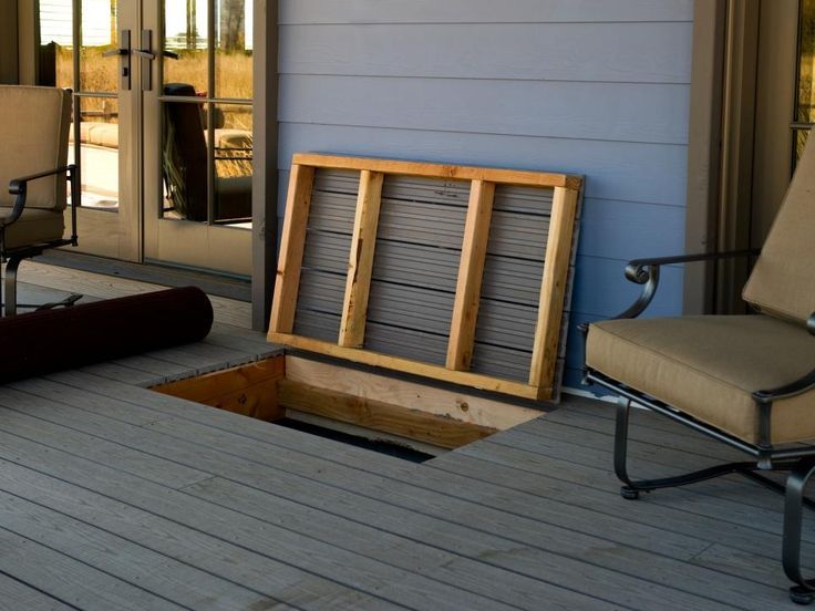 a chair sitting on top of a wooden floor next to a fire pit in the middle of a porch