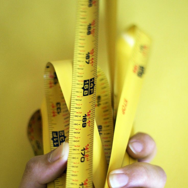 a person holding two yellow rulers in their hands