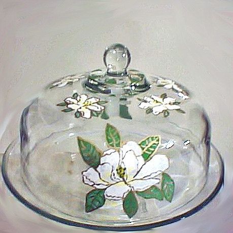 a glass dish with flowers on it sitting on a table