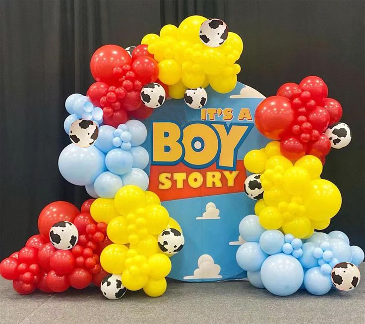 there is a boy story sign with balloons in the shape of cows and soccer balls