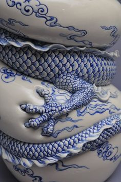 two blue and white vases stacked on top of each other, one with a dragon design