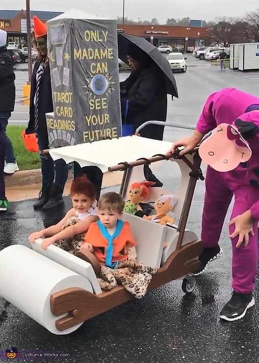 two children in costumes are riding on a cart