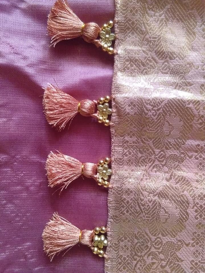 three tassels are hanging from the side of a pink fabric with gold beads