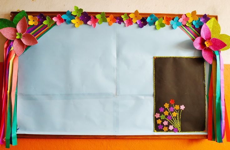 an art project with paper flowers and ribbons on the front of a bulletin board that is decorated in bright colors