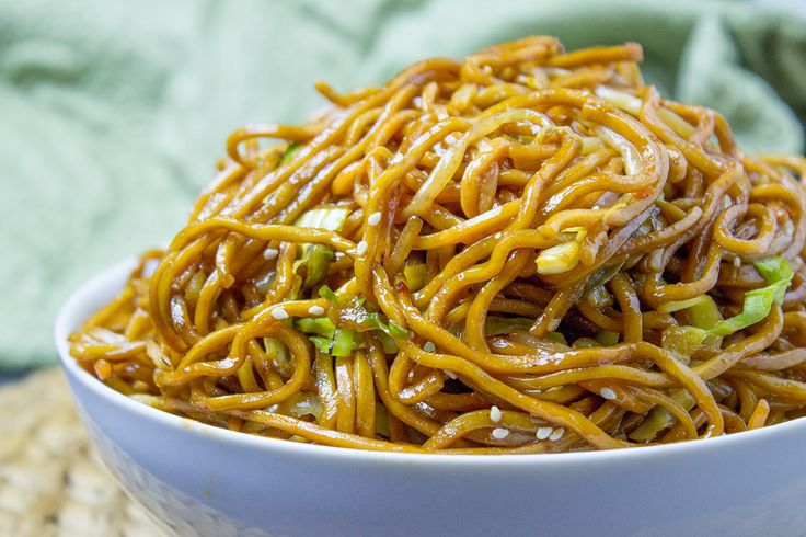 a white bowl filled with noodles on top of a table