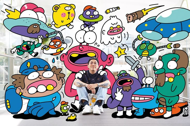 a man sitting in front of an image of cartoon characters