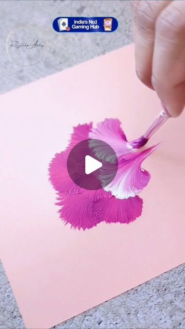 someone is painting an apple logo on a piece of paper with pink and purple feathers