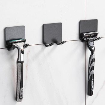 three toothbrushes and two razors are hanging on the wall with magnets