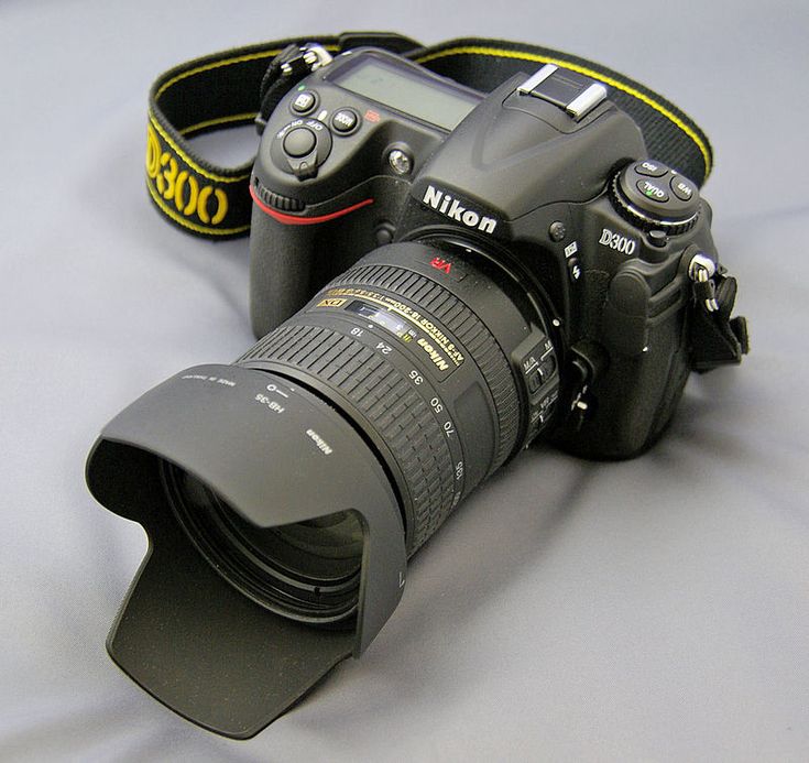 a digital camera sitting on top of a table next to a flash drive and strap