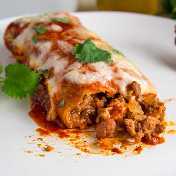 a close up of a plate of food with meat and sauce on it, garnished with cilantro