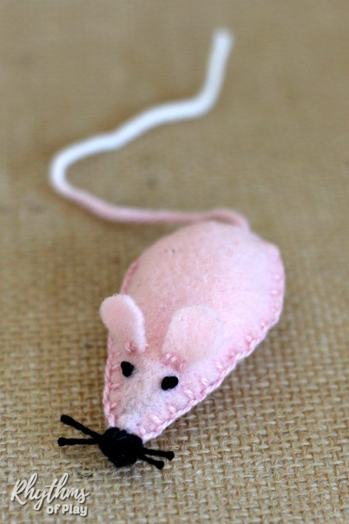 a pink felt mouse is sitting on the ground