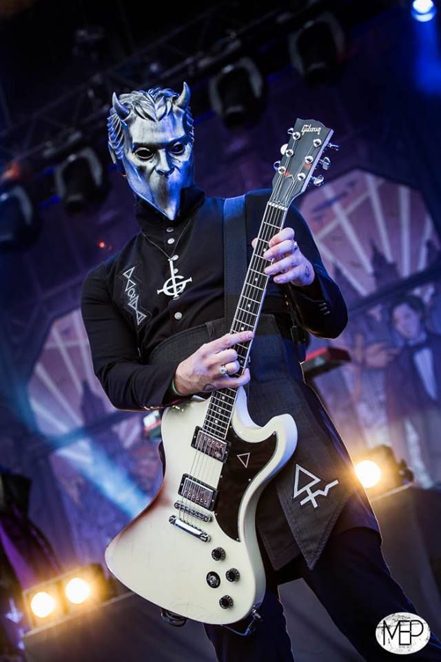 a man with blue makeup playing an electric guitar