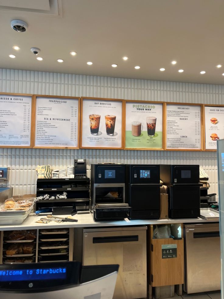 there are menus on the wall above the coffee machines in this restaurant that is open for business