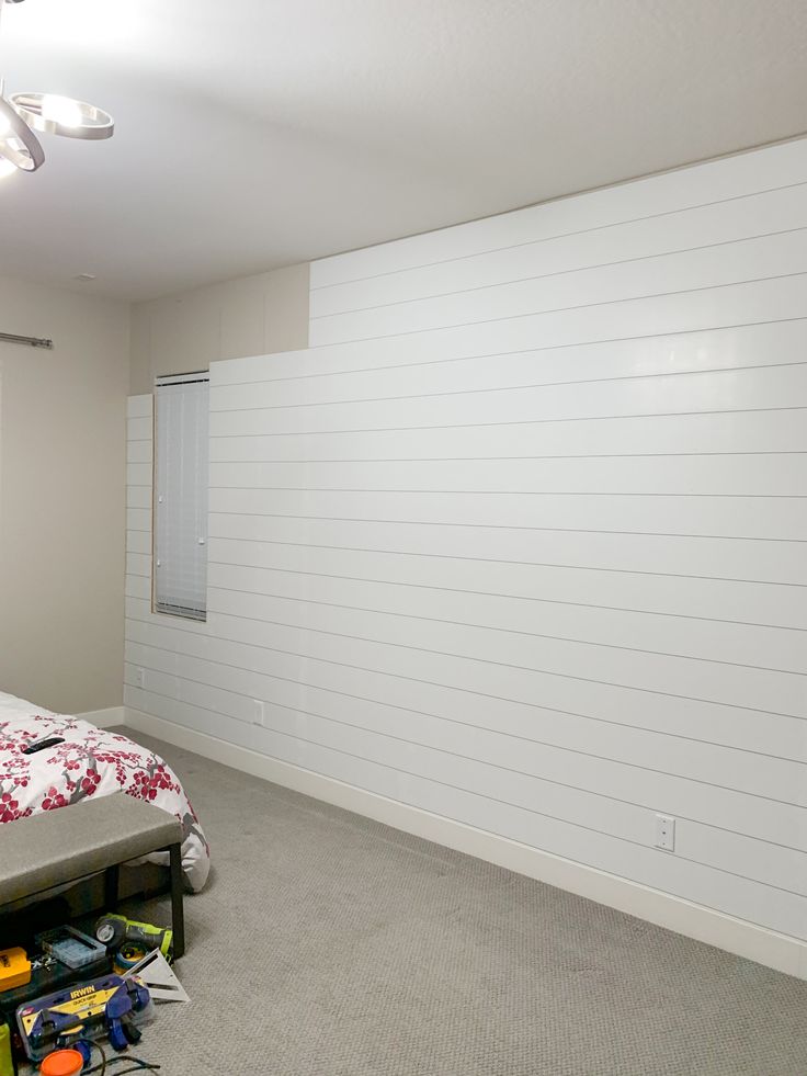 an empty room with a bed and tools on the floor