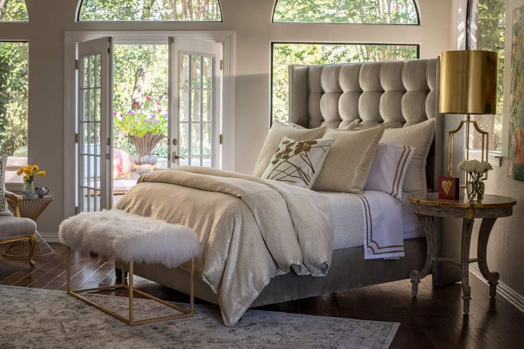 a large bed sitting in a bedroom on top of a hard wood floor next to a window