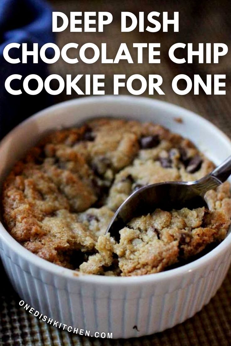 deep dish chocolate chip cookie for one is in a white bowl with a spoon on the side