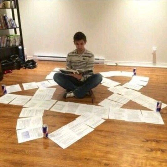 a man is sitting on the floor surrounded by papers