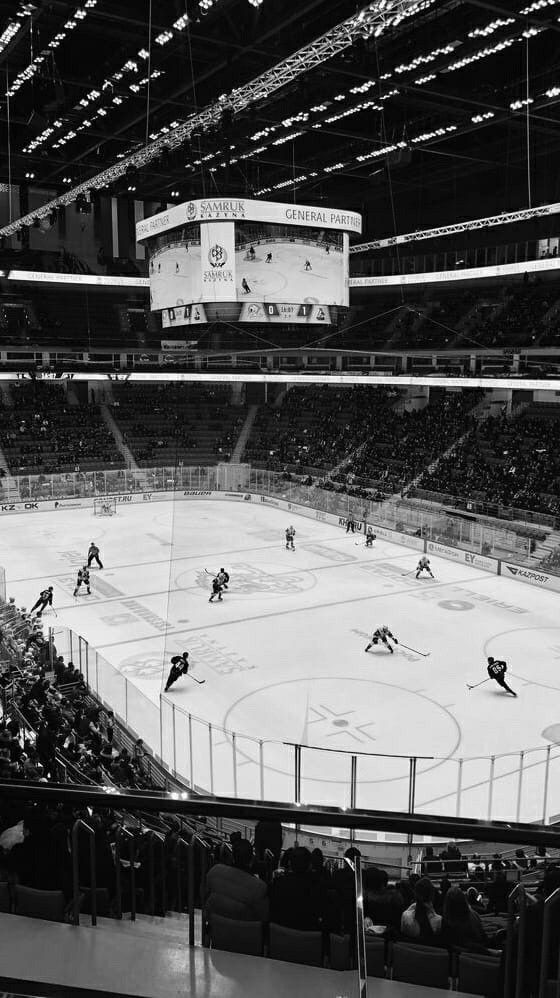 an ice hockey game is being played in a large arena with people watching from the stands