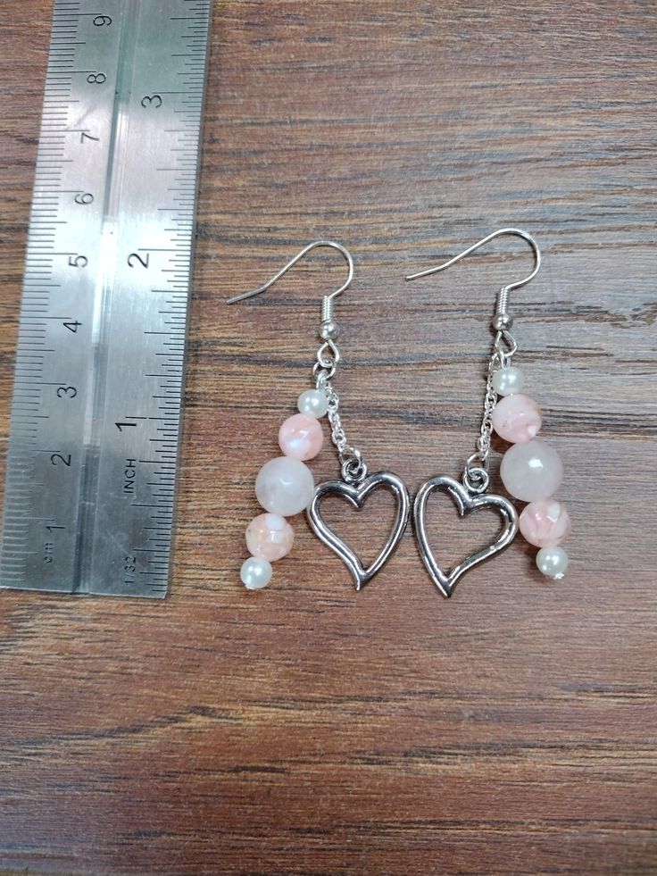 2 inch pink drop earrings. Silver heart charm attached by short silver chain. Metal Dangle Heart Earrings With Heart Charm, Trendy Dangle Heart Earrings With Ear Wire, Elegant Pink Heart Metal Earrings, Metal Dangle Heart Earrings With Heart Beads, Metal Heart Beads Drop Earrings, Heart Beads Metal Drop Earrings, Metal Heart Dangle Earrings With Heart Beads, Metal Dangle Earrings With Heart Charm, Dangle Heart Bead Earrings