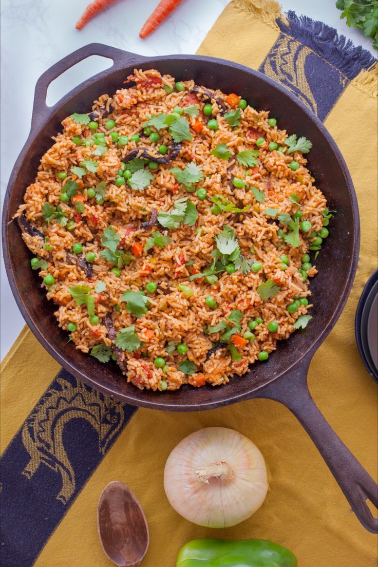 a pan filled with rice and vegetables on top of a table