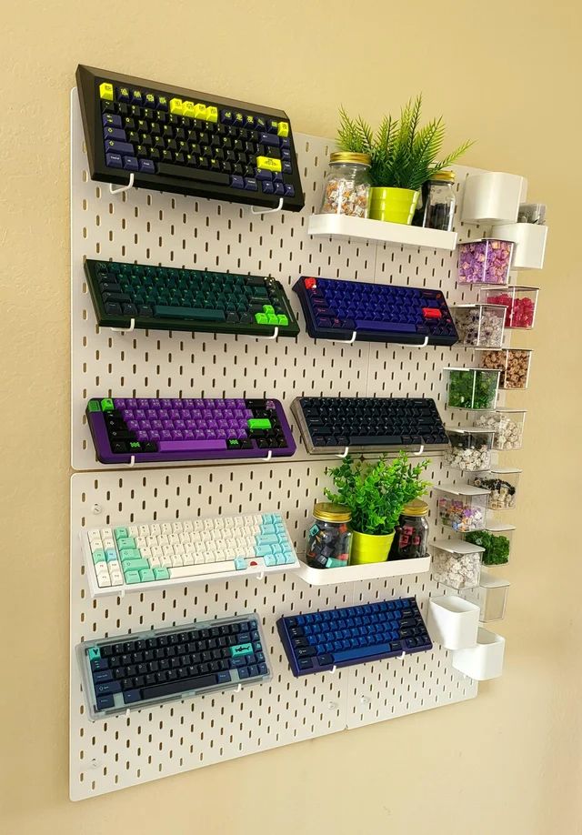 there is a wall mounted rack with several keyboards on it and plants in the background