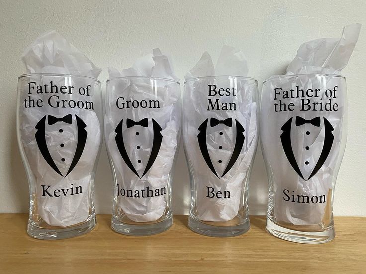 three personalized glasses with the names of grooms and best man on each one