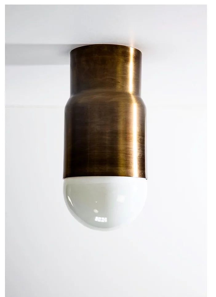 a close up of a light fixture on a white wall with a black and gold finish